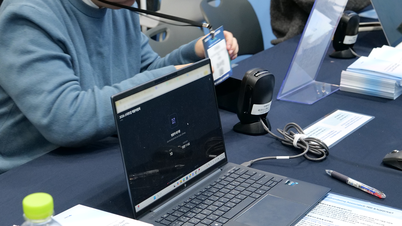 기업 부스에서 참가자 명찰 QR을 스캔해 부스 방문 데이터를 수집하는 장면
