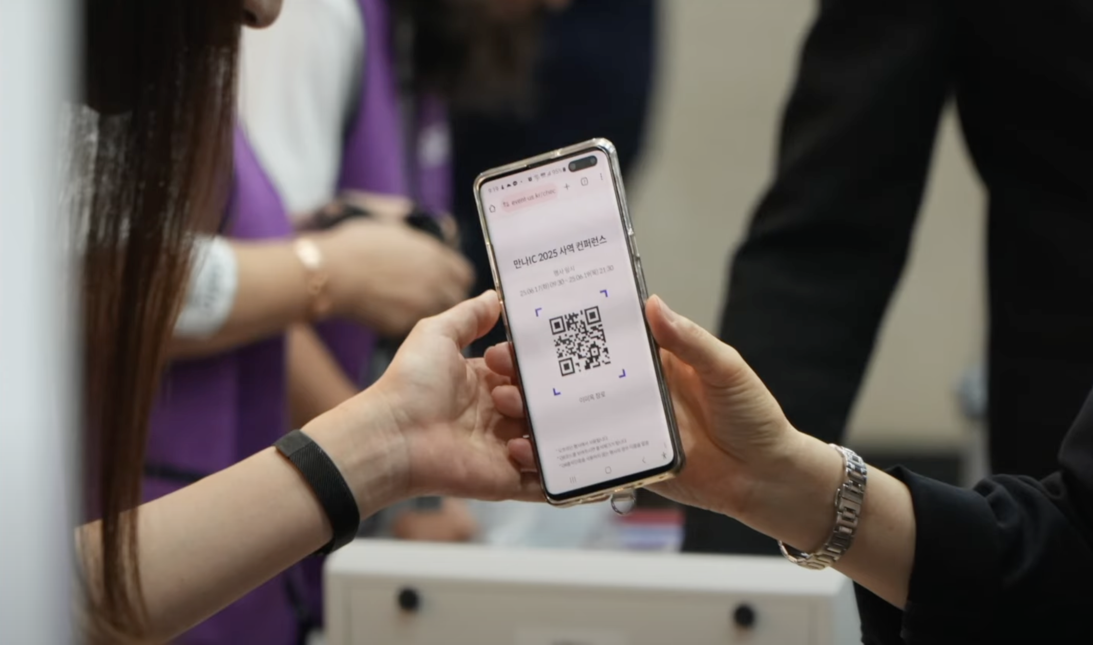 등록데스크에서 입장 QR코드로 체크인하는 참가자 모습
