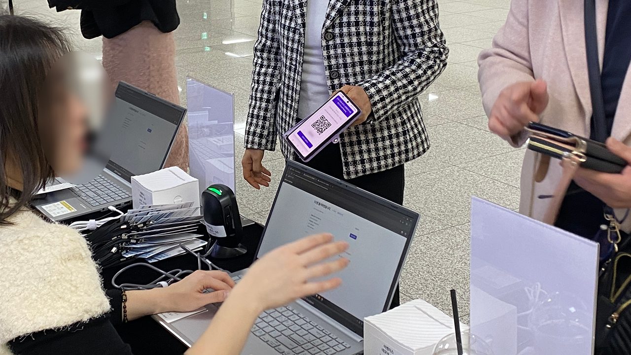 참가자가 스마트폰 QR코드를 스캔하는 장면